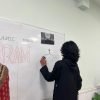 Teacher writing on a whiteboard during a class at BKM Community