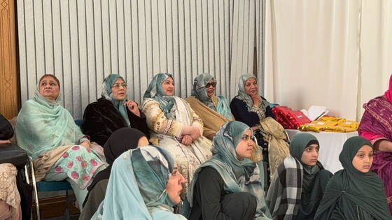 Women seated together in a circle during a community study session at BKM Community, Manchester