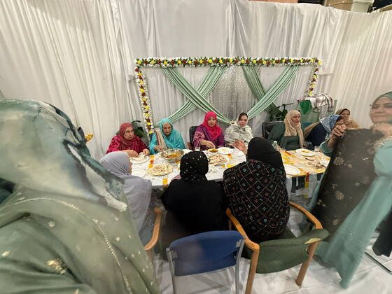 Community members seated under a marquee during a large outdoor gathering